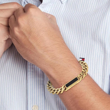 Ανδρικό βραχιόλι ατσάλινο Tommy Hilfiger 2790539 σε χρυσό χρώμα και χρυσή αγκράφα και μαύρη πέτρα.